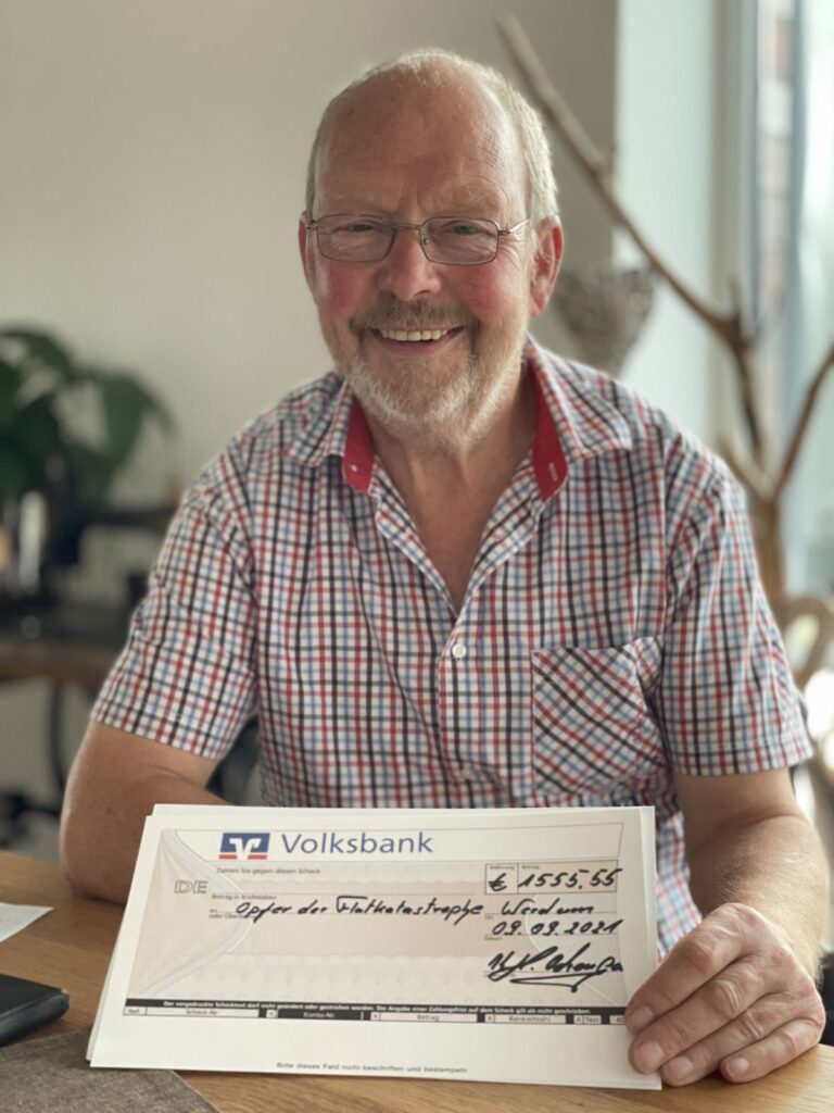 Kalle Ockenga zeigt stolz den Scheck mit den erwirtschafteten 1.555,55 € für die Flutopfer