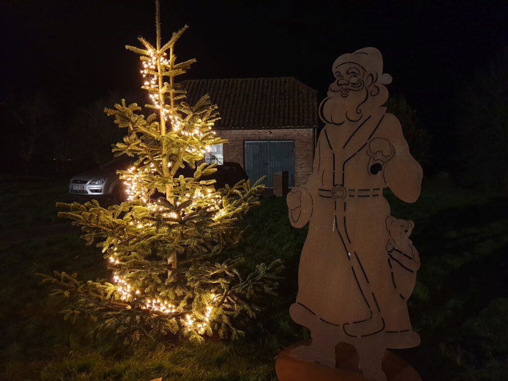 Auch vor der Schmiede steht wieder ein Baum und der Weihnachtsmann schaut zu