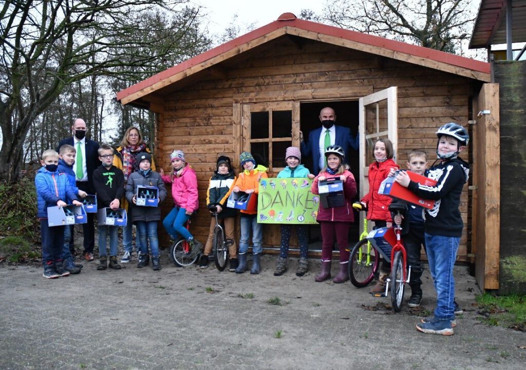 Die NV-Vertreter Thomas Pieper (li) und Thomas Beske (Mitte) überreichten 12 Fahrradhelme an die Einradfahrer. Mit den Kindern freute sich Lehrerin Jutta Cremer  (2.v.Li.)