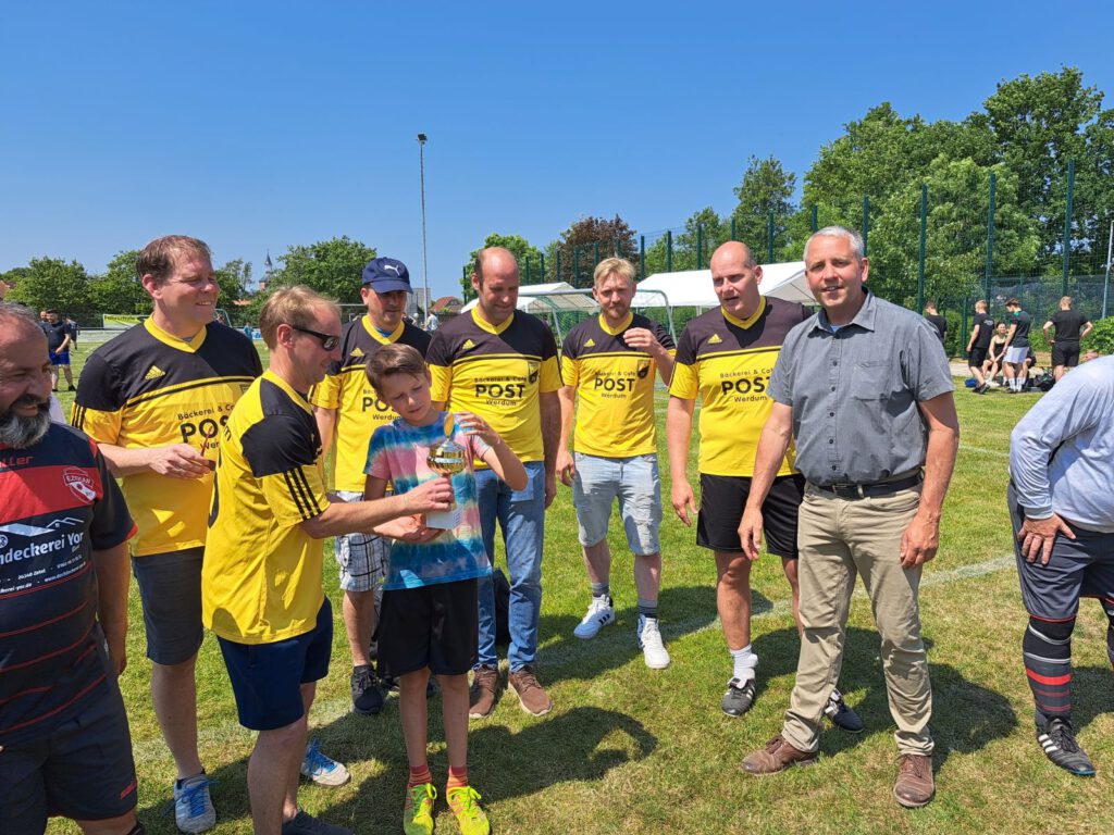 Der Bürgermeister hat den von der Gemeinde Werdum gestifteten Pokal an Spielführer Jan Breithaupt überreicht.