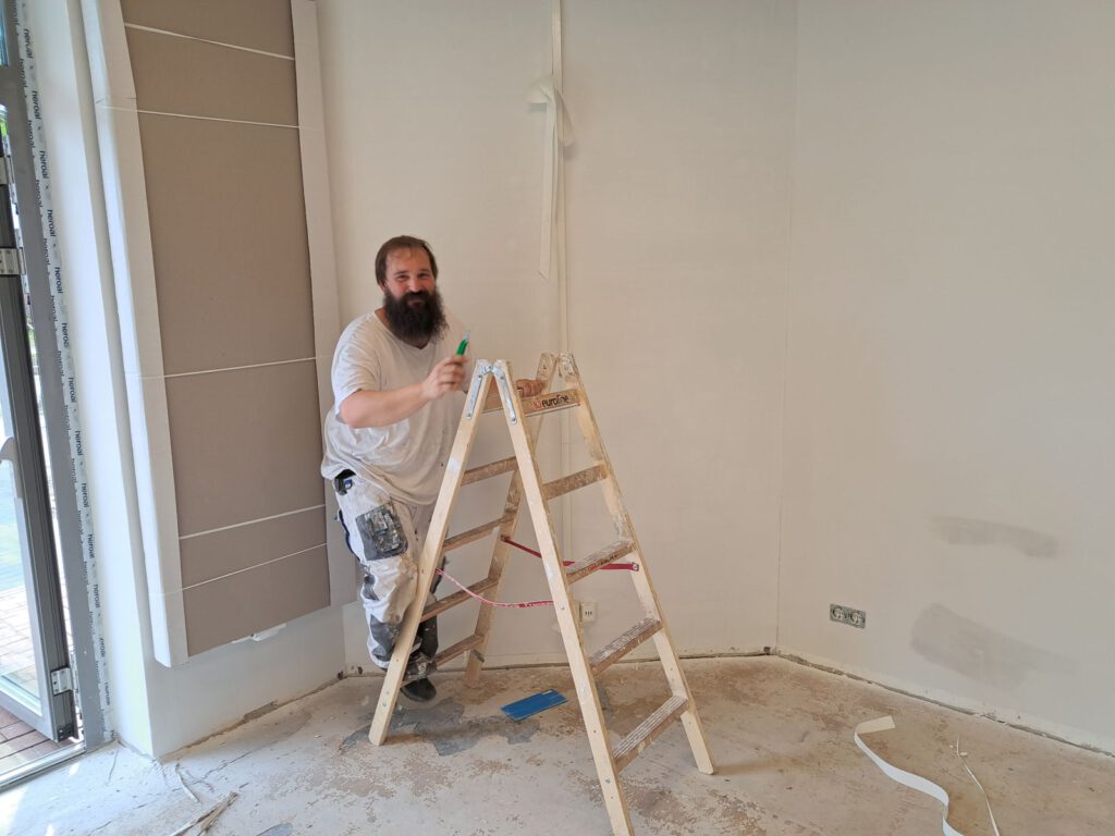 Sascha Kramer besteigt die Leiter und streicht die Wände neu