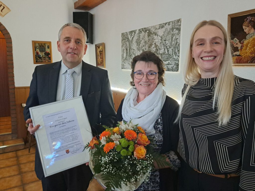 Debora Vogel ist "Bürgerin des Jahres". Bürgermeister René Weiler-Rodenbäck und sein Stellvertreterin Tanja Immega gratulieren ihr mit Urkunde und Blumen