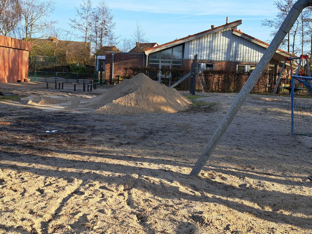 der große Sandhaufen wird auf dem Schulhof verteilt