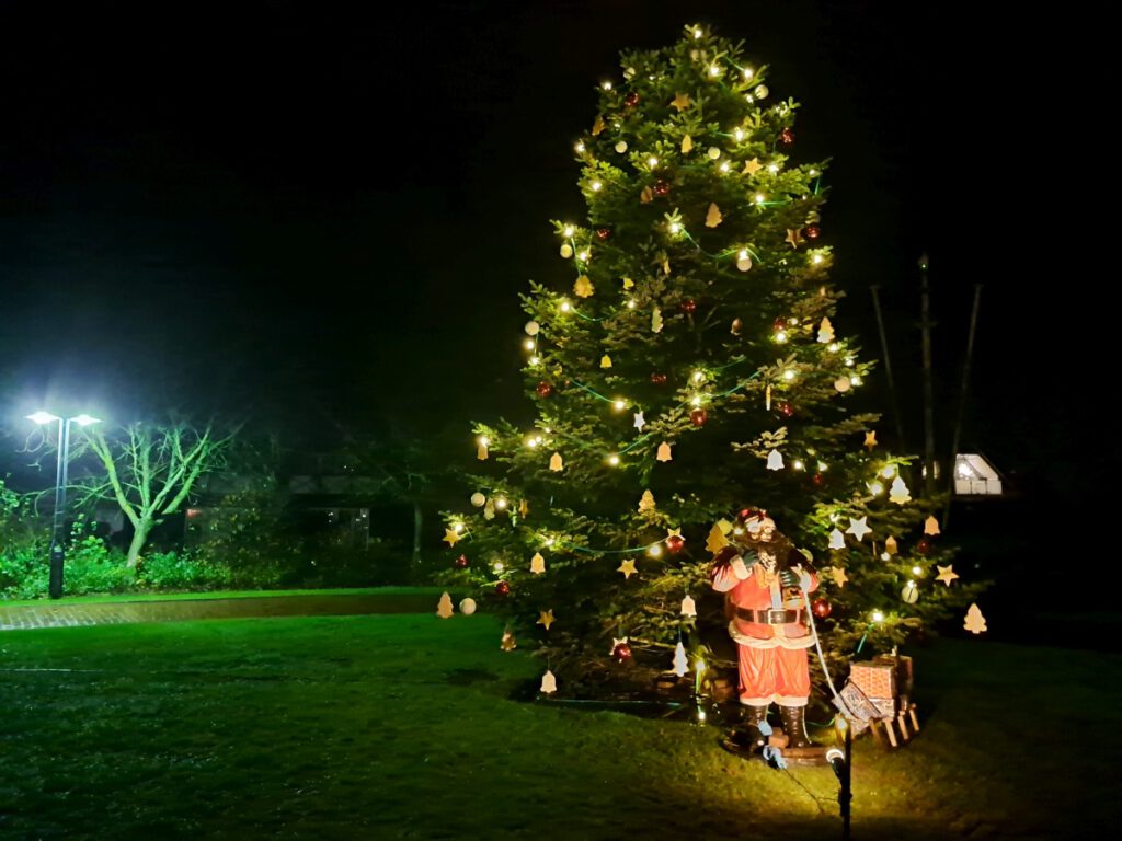 Der große Baum auf dem Dorfplatz mit Weihnachtsmann sticht natürlich heraus 