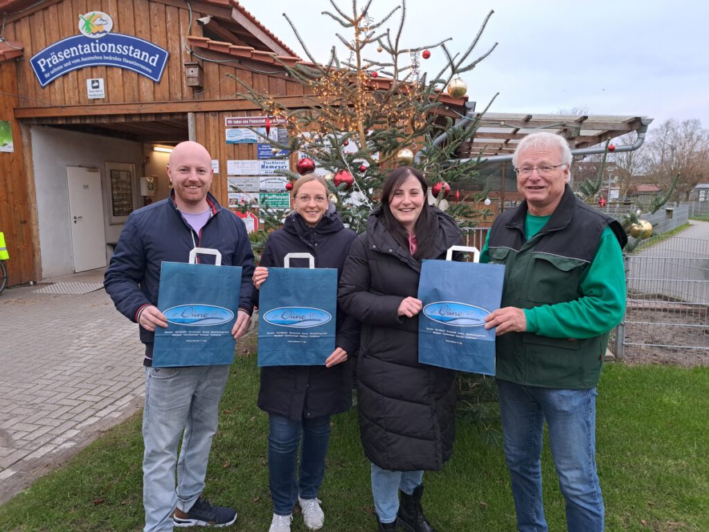 Marius Herr (l) und seine Schwester Franziska Janssen (2.v.R) überreichten Sandra Lange und Johann Pieper die große Spende die sie für die mitgebrachten umweltfreundlichen Papiertüten eingesammelt haben 