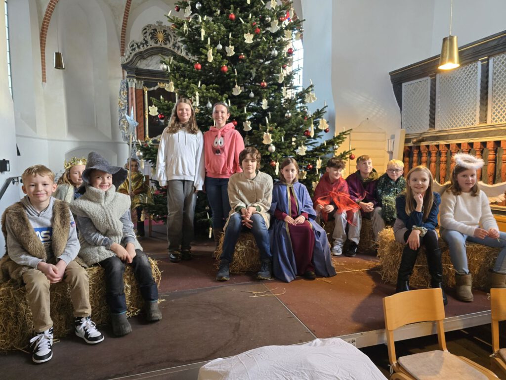 Die Krippenspieler bei der Generalprobe vor dem geschmückten Weihnachtsbaum in der St.-Nicolai-Kirche